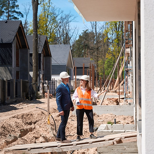 Two construction professionals reviewing plans on a job site
